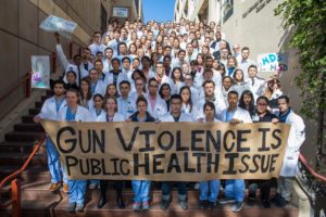 DFA members hold a "Gun Violence is a Public Health Issue" banner